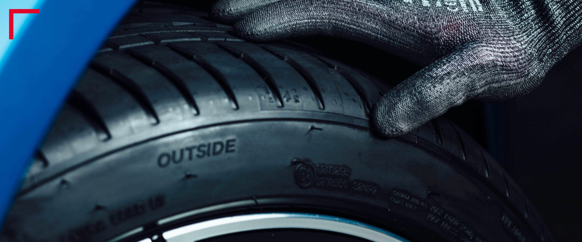 Hand in glove touching tire Image